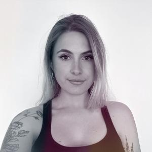 Žena s dlouhými blond vlasy a tetováním na levé paži, má tmavé tílko a dívá se přímo do kamery. Jmenuje se Tereza Kozubková a má nastarosti influencery i spolupráce v českém e-shopu BrainMarket, který se zaměřuje na podporu zdravého životního stylu a biohackingu.